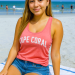 Elli Lopez on Fort Myers Beach, wearing jean shorts and a pink Cape Coral shirt.